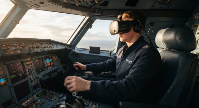 Ein Pilot mit VR-Headset sitzt konzentriert in einem detaillierten Flugzeug-Cockpit bei der Landung.